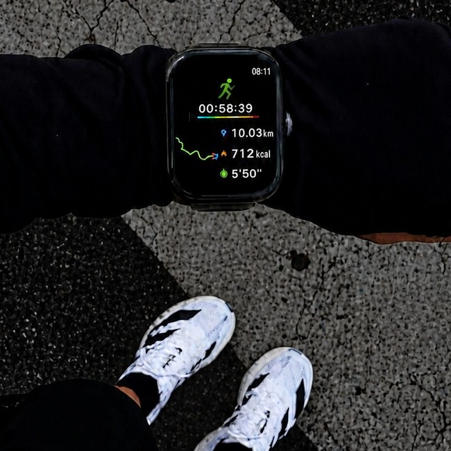 Vista desde arriba de un reloj deportivo marcando 10,03 km y 712 kcal tras una carrera, con unas zapatillas blancas de fondo.